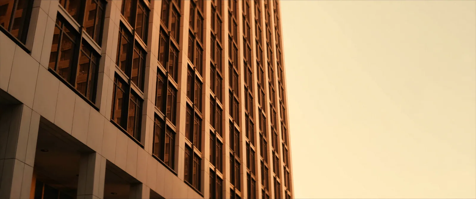 Torre corporativa de oficinas vista desde abajo con luz dorada